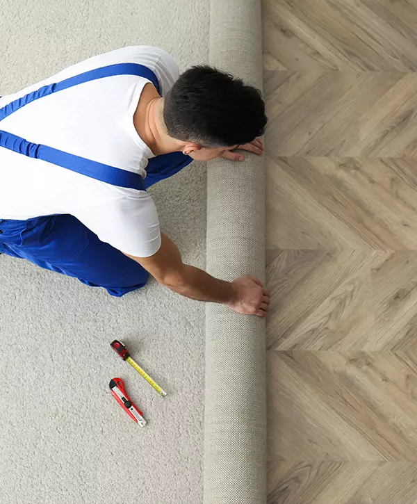 Worker rolling aout new carpet indoors, above view Loop Carpeting In Modesto, Turlock, Tracy, And More Of CA