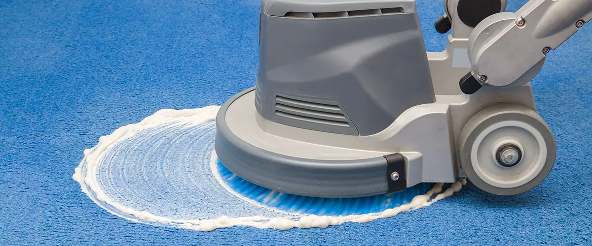 Blue carpet chemical foaming carpet cleaning solution, rubbing and cleaning with professionally disk machine. Early spring regular cleanup